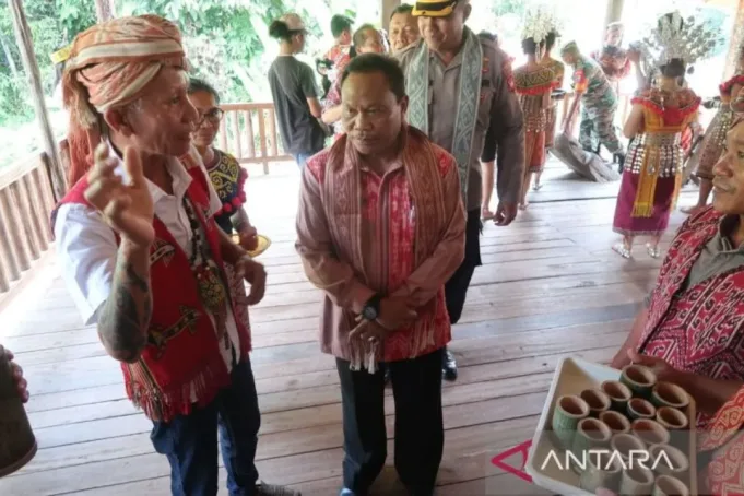 Sekretaris Daerah Kabupaten Kapuas Hulu Mohammad Zaini (kanan) mendengarkan penjelasan Kepala Desa Batu Lintang Raymundus Remang (kiri) tentang tata cara memasuki rumah bentang yang dihuni masyarakat adat Dayak Iban Menua Sungai Utik di Desa Batu Lintang, Kecamatan Embaloh Hulu, Kabupaten Kapuas Hulu, Provinsi Kalimantan Barat, Jumat (28/7/2023). ANTARA/Sugiharto Purnama